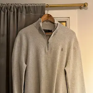En grå half zip tröja från Ralph Lauren. Den sitter bra i storleken och är i gott skick.