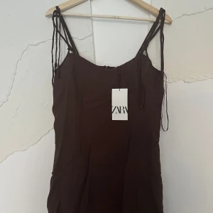 Brun superfin långklänning från zara - Ny superfin ny långklänning från zara i linnematerial, därför lite skrynklig på bilderna. Perfekt sommarblåsa och så bekväm. Är ned på fötterna på mig som är 162cm