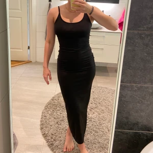 Tight långklänning - En svart midiklänning från shein i väldigt fint skick. Materialet är glansigt och stretchigt. Köparen står för frakt.