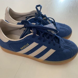 Nya retro Adidas Gazelle - storlek 36 - Adidas originals gazelle j i storlek 36 (rymlig) Marinblå och beige (night indigo/wonder taupe). Nya och oanvända med tags. Kommer stt uppdatera med egna bilder samt mått innersula Populär färg vintage inspiration. Slutsålda.  Handball Spezial Samba