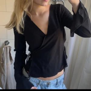 Svart blus - Luftig blus från weekday som man knyter! Den har slits i armarna!