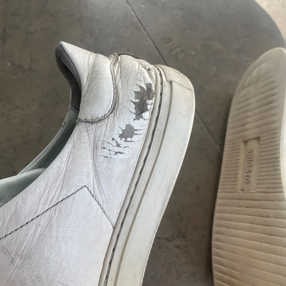 Välanvända vita Arigato skor. Creasade och färgen har lossnat på några ställen.. Skor.