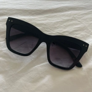 Solglasögon - Svarta solglasögon från Nelly. Nyskick.