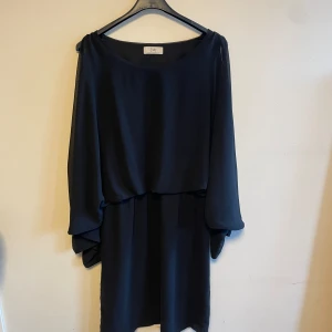 Svart klänning  - Svart långärmad klänning med öppna axlar 