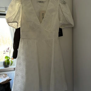 Klänning  - Vi klänning som är helt oanvänd med prislapp kvar. Den är normal i storleken och sitter väldigt fint på.