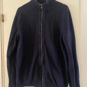 Stickad cardigan  - Stickad mörkblå cardigan från Kappahl i storlek M. Bra begagnat skick. 