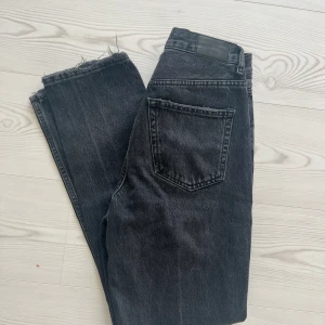 Svart/gråa jeans - Jeans från Ginatricot. Medel till hög midja. Använda ett par gånger men inga märkbara defekter. Stl 34 men passar även mig som är en 36