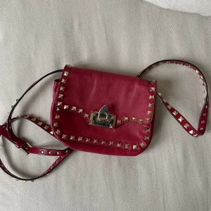 Valentino väska - Säljer min röda Rockstud Valentino väska. Har repor på framsidan men kan säkert åtgärdas med läderbalsam. Insidan är smutsig. Vid intresse kan äkthetsbevis uppvisas. Nypris ca 10 000kr.