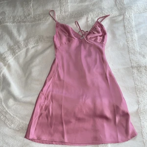 Rosa silkes klänning från Bershka  - Fin Bershka klänning i silke. Klänningen är i den mörkrosa nyansen och har justerbara axelband. Klänning är köpt för ett år sedan men bara använd ett fåtal gånger då den är ett snäpp för litet 🥰