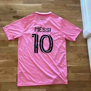 Messi T-shirt  - Det är en Fotbollströja med Messi på. Har alldrig Används, köp dyrt på en marknad i Spanien/Mardrid, skriv till mig om du har frågor.