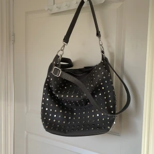 Grå väska med nitar - Säljer denna fina gråa axelremsväska! Köpte second hand men är i superbra kvalité!