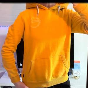 Fin gul/orange Hoodie från superdry med både tryck i fram och bak.  Original pris ca 1000kr