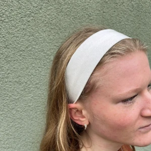 Vitt hårband med knapp - Stilrent hårband med knapp som gör hårbandet jättesmidigt att ta på, eftersom du slipper att smink smutsar ned under på-/avtagning💚