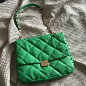 Grön handväska från H&M man kan använda som både criss cross bag & korta ner bandet till axelväska