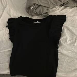 En jätte fin somrig svart tröja från zara sitter jätte fint i midjan inte för tajt men inte för pösig. - Sitter otroligt bra i armarna o midjan.