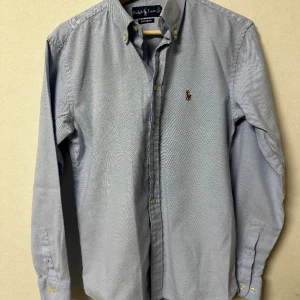Ralph lauren skjorta  - En blå skjorta i perfekt skick, för det inte finns något som helst fläckar eller skador. Det står storlek M men skulle nog säga att den är mer storlek S och kanske XS.