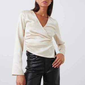 Supersnygg Wrap satin blouse från Gina Tricot i storlek S. Använd 2 gånger, säljer pågrund av att jag tycker den är lite för tight på mig. Sömmen i ena armen har spruckit ca 1 cm, enkelt att laga!
