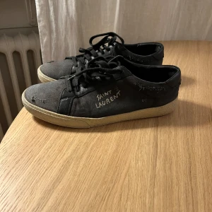 SAINT LAURENT SKOR - Tjena! Säljer mina svarta sneakers från YSL. Skorna är i fint skick och storleken är 42,5. Hålen är givetvis en del av designen;) Hör gärna av er om ni vill ha fler bilder eller och är intresserade 👑