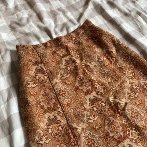 Lång kjol - Lång kjol. Rätt tjockt tyg. Liten i midjan och ingen stretch. Varken märke eller strl står. 