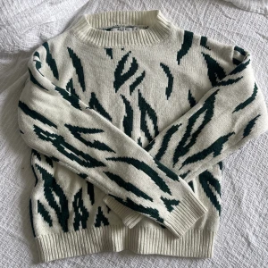 Stickad tröja med tryck - Stickad tröja med mörkgrönt tryck, köparen står för frakt 