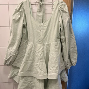 Mintgrön klänning - Mintgrön klänning från Nalina, är lite längre bak så räcker väl! Även lite tyngd i klänningen på volangerna för att den inte ska flyga upp! Helt ny och slutsåld 