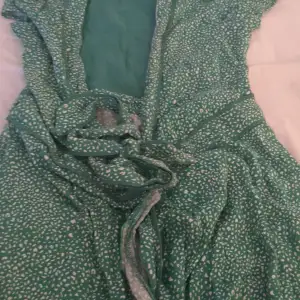 Grön leopardmönstrad klänning med knyte där fram och volanger längst ner