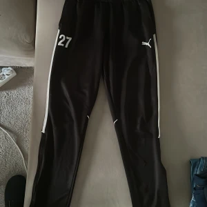 Puma mjukisbyxor - Puma mjuksbkxor med siffra 27 liten fläck på baksida och en defekt vid knät 