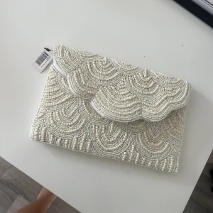 Clutch väska  - Superfin benvit clutch, finns kedja till! Aldrig använd, prislapp sitter kvar