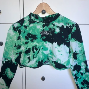 Cool grön croptop från H&M - Cool grön svart och vit långärmad croptop från H&M! Använd ett flertal gånger, men i bra skick! Tröjan är i storlek S, pris 55kr. Köpare står för frakt.