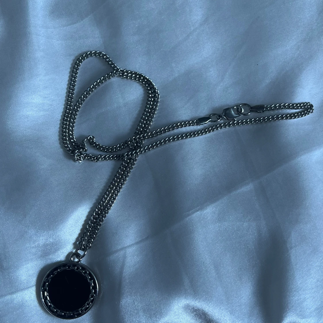 Silvrigt halsband med svart detalj på 