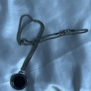 Silvrigt halsband med svart detalj på  - jag säljer detta halsband då jag inte använder det, halsbandet är inte min stil