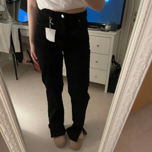 Svarta jeans  - Helt nya svarta jeans med prislapp från bikbok, modellen är högmidjad med raka ben som har slits nertill, storlek 30/32