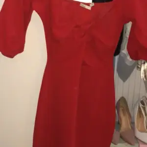 En tight röd klännnin som är lite öppen vid bröstet 