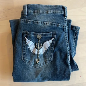 Jeans med broderi på bakfickorna - Jättesnygga jeans med broderi på bakfickorna. De är bootcut. Köptes på Temu, men säljs då de var lite för korta på mig. Skulle säga att de är ganska så stretchiga.