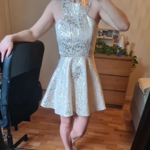 Festklänning i guld/vit - Festklänning i fint skick, endast en gång använd.