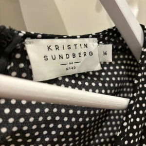Prickig Jumpsuit, Kristin Sundberg for NA-KD - Prickig Jumpsuit med djup urringning och band i midjan från Kristin Sundbergs samarbete med NA-KD Normal i storleken  Använd fåtal gånger 