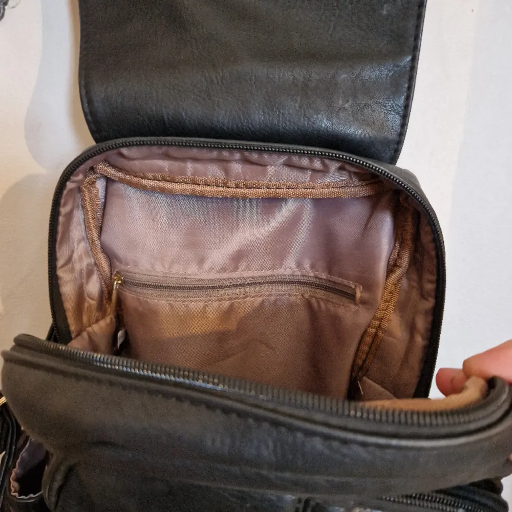 Liten läderryggsäck i bra kvalite. Släppt i en söm i en av innerfickorna. . Väskor.