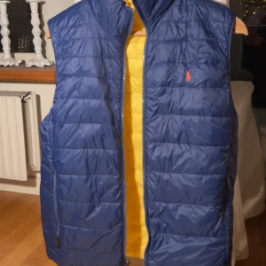 Ralph Lauren väst  - Oanvänd tvåsidig Ralph Lauren väst💙💛Storlek:Barnstorlek XL Färg:Mörkblå och Gul  Nypris:Osäker Säljer:500kr Pris kan diskuteras🌟