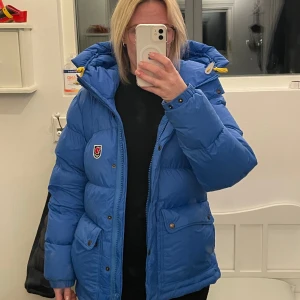 Fjällräven Down Lite - Fantastiskt fin blå Fjällräven klassiska dunjacka. Köpt för fullpris 6500 kr år 2023.