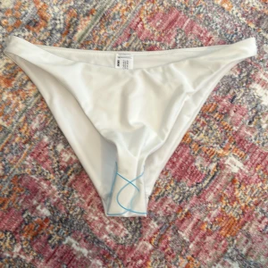 Vit bikiniunderdel  - Aldrig använd bikiniunderdel från ASOS, säljer den pga att den är för stor och kunde ej lämna returnera den. Storlek 38. Nypris 199kr.