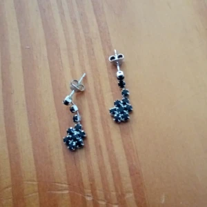 Örhängen med svarta stenar. - Örhängen silverfärgade med svarta stenar.