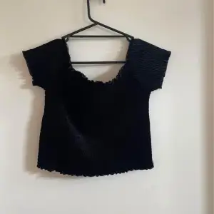 En svart croppad offshoulder top från bikbok 