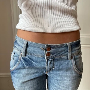 Lågmidjade bootcut jeans från only - Snygga unika lowwaist bootcut jeans i ljusblå färg från only. Super populära och slutsålda. Justerbara i midjan.