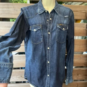 Snygg jeansskjorta från Lee stl M - Osäker på om denna är en dam em herr modell då jag fått den i present. Skulle säga unisex. En rak/smal herrmodell el rak/lös dam. Mycket fint skick! Nypris runt 800:-