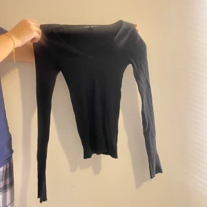 Svart topp - Svart basic ribbad topp med v-ringning. Den är tajt och formar kroppen väldigt fint.