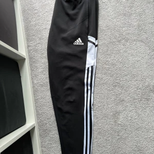 Adidas träningsbyxor stl L - Adidas svartvita träningsbyxor, herrmodell, i WCT-material, storlek L. Mycket fint skick. 