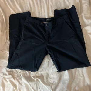 Mörkblå kostymbyxor - Mörkblå kostymbyxor, det står inte riktigt storlek men jag skulle säga 40/42. De är låga i midjan och raka i modellen. Från Atlanta.