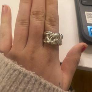 En ganska stor flätad silver ring. Inte äkta. Köptes på glitter men säljer den eftersom att den är lite stor. Knappt använd💗💗 bara att skriva om ni har några funderingar💗