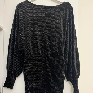 Nyårsklänning - Svart glittrig klänning i storlek S men stretchig material så kan även passa M. Den har använts en gång och har inga slitningar. Klänningen är från ginatricot men sälja inte längre. Säljer för 250kr, pris kan diskuteras, hör av er för fler bilder!  