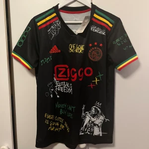 Ajax x Bob Marley fotbollströja - Ajax collaboration med Bob Marley, riktigt snygg och skön tröja, perfekt till sommaren! Helt ny, säljer för den var lite för liten.